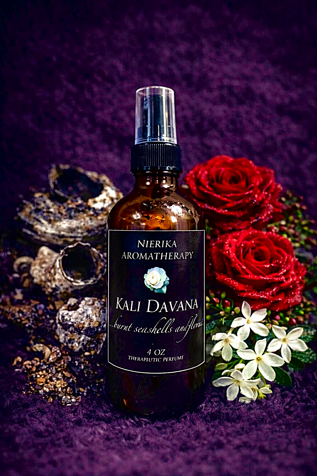 Kali Davana therapeutic perfume spray by Nierika Aromatherapy, burnt seashells and flowers, shown with seashells and red roses – 4 oz