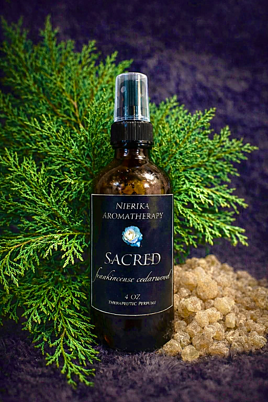 Sacred therapeutic perfume spray by Nierika Aromatherapy, frankincense and cedarwood, displayed with cedar branches and frankincense resin – 4 oz